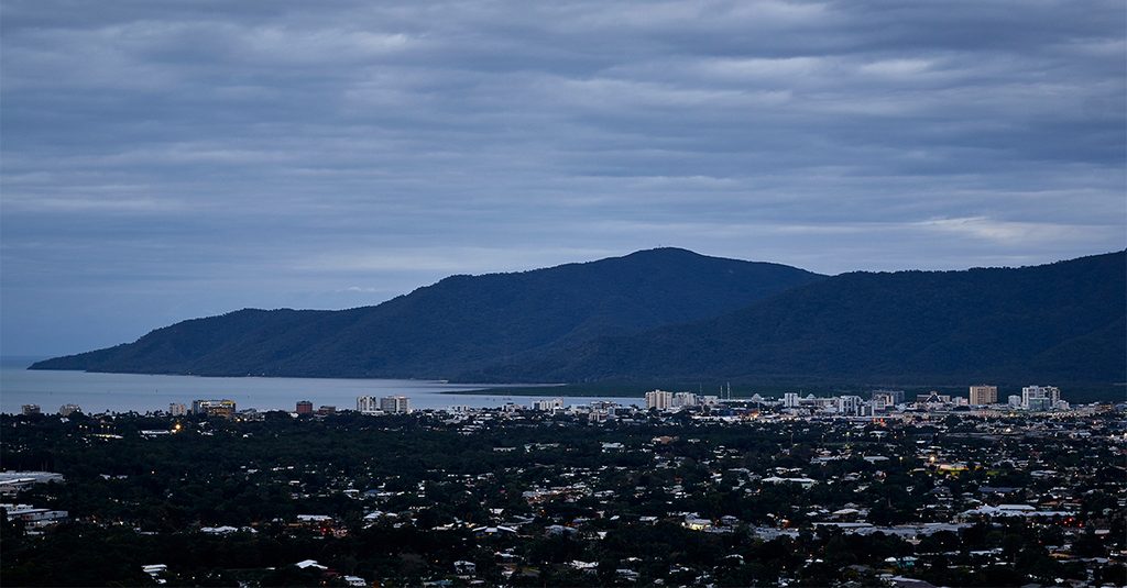 Heavy grey clouds over the Cairns skyline and coastal ranges at dusk, as local businesses plan their IT strategy for the wet season